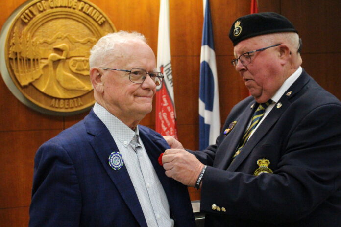 Deputy Mayor Mike O'Connor (L) accepts the city's first poppy of the year from Dean Langton (R) (Ethan Montague, MyGPNow.com Staff)